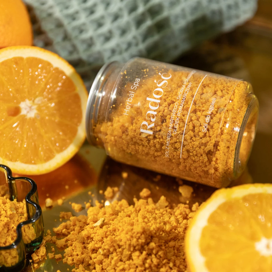 Radość – sól do kąpieli z pomarańczą 250 g Herbal SPA wśród plastrów pomarańczy